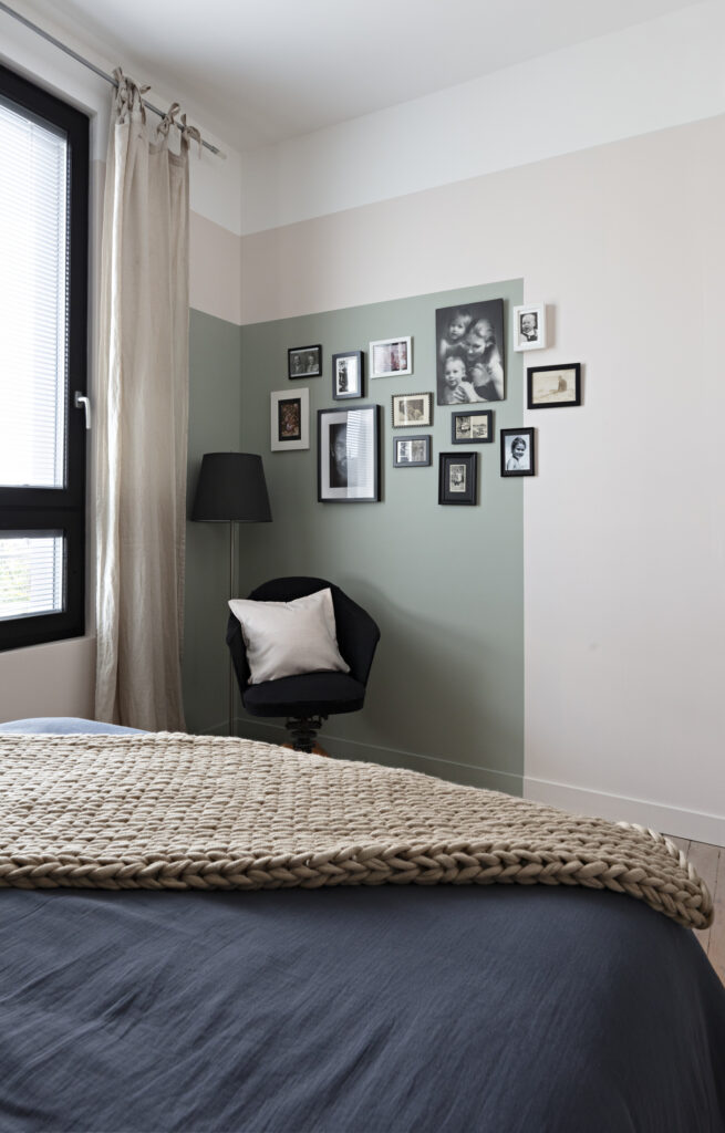 Détail d'une tête de lit avec bibliothèque intégrée, tablette en chêne et suspension design dans une décoration complète de maison à Nantes.
