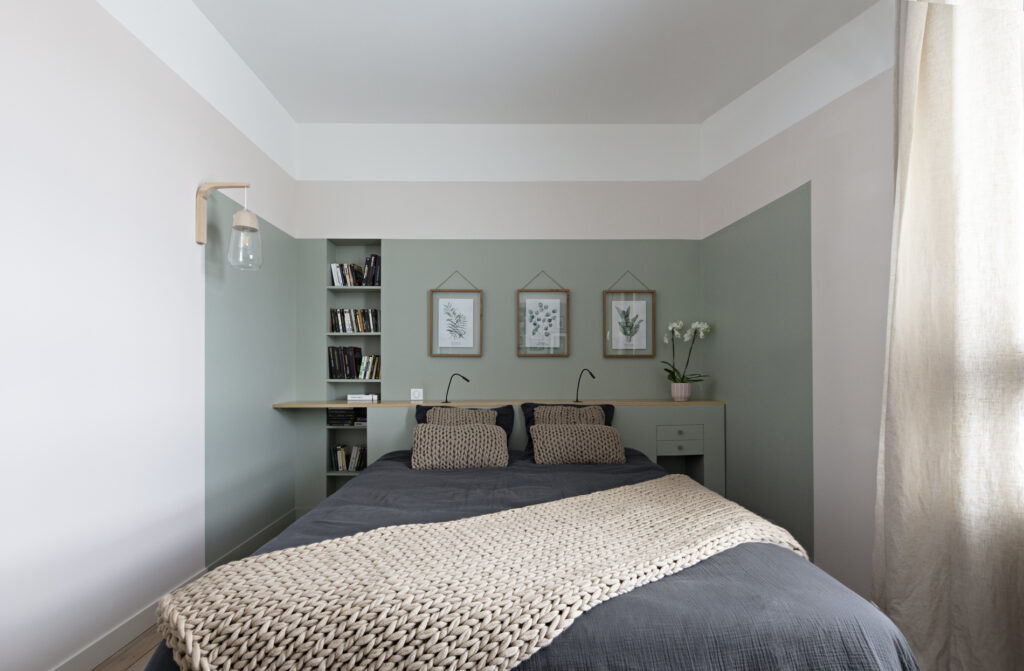 Chambre parentale avec tête de lit intégrée, bibliothèque, éclairages de lecture et décoration vert sauge dans une maison rénovée à Nantes.
