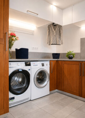 Coin buanderie avec lave-linge, sèche-linge et nombreux rangements dans une arrière-cuisine multifonction à Damgan.