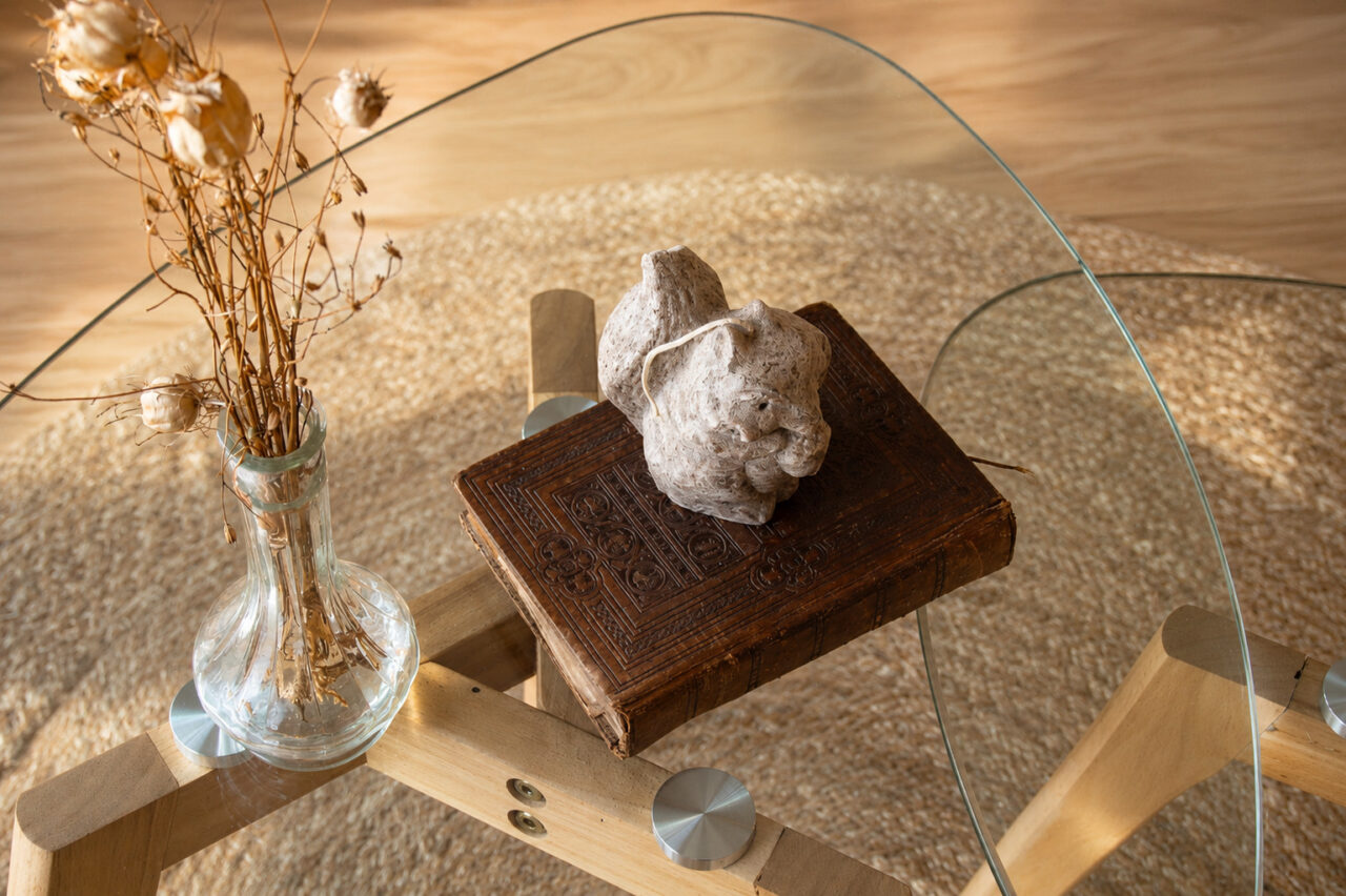 Gros plan sur la décoration du salon rénové après sinistre à Nantes avec table basse en verre, livre ancien et objets décoratifs.