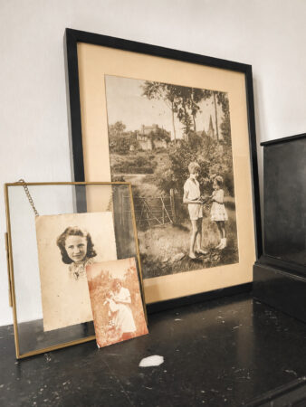 Photographies anciennes mises en scène sur une cheminée restaurée dans une rénovation d'appartement ancien à Nantes.