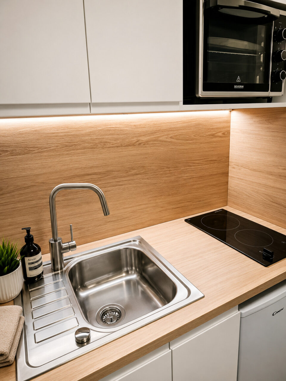 Évier inox, plan de travail bois et crédence du studio locatif rénové dans un immeuble classé du quartier Graslin à Nantes.