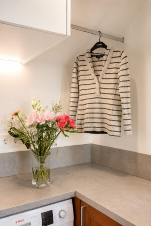 Barre de séchage intégrée sous les meubles hauts dans une arrière-cuisine buanderie multifonction aménagée à Damgan.