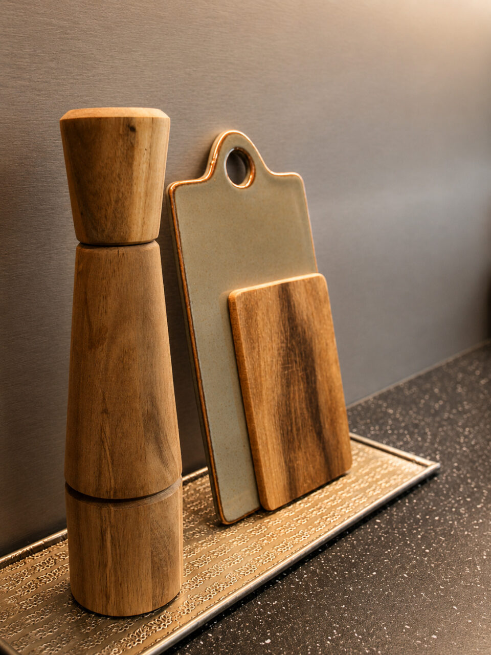 Planches à découper en bois et moulin disposés sur le plan de travail d'une cuisine rénovée après sinistre à Nantes.