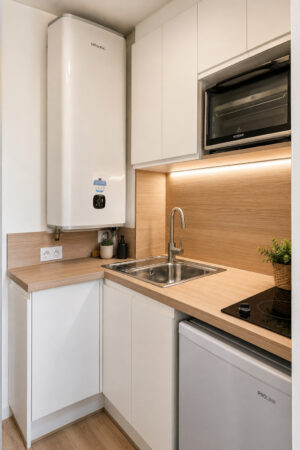 Kitchenette optimisée après rénovation dans un studio locatif d'un immeuble classé du quartier Graslin à Nantes.