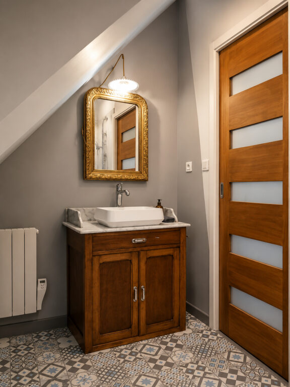 Ancien meuble de famille transformé en meuble vasque dans une salle de bain rétro sous combles à Sautron