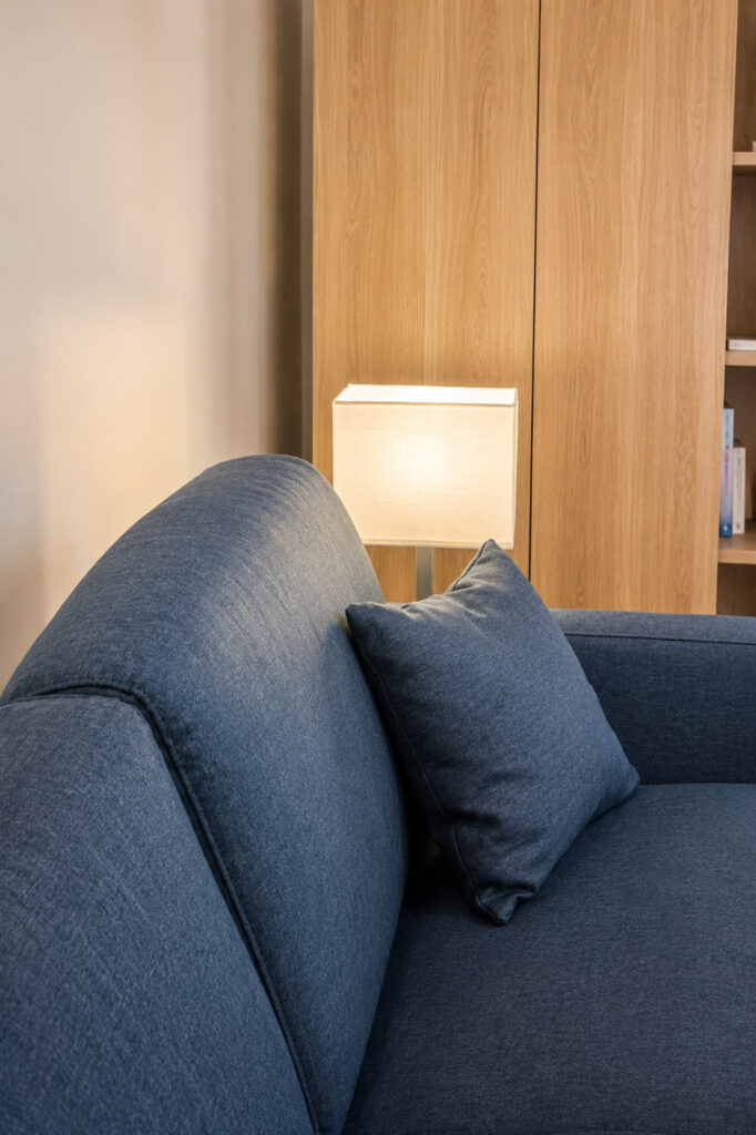 Canapé et mobilier en bois aménagés dans le studio locatif rénové du quartier Graslin à Nantes.