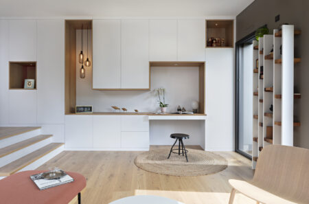 Agencement sur mesure en chêne et laque blanche intégrant bureau et rangements dans une décoration complète de maison à Nantes.