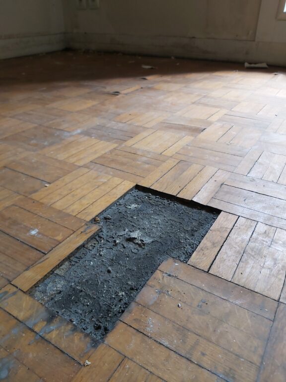 Détail du parquet ancien dégradé avant rénovation complète après sinistre à Nantes