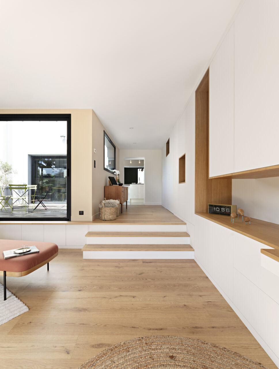 Agencement sur mesure en chêne et laque blanche intégrant bureau et rangements dans une décoration complète de maison à Nantes.