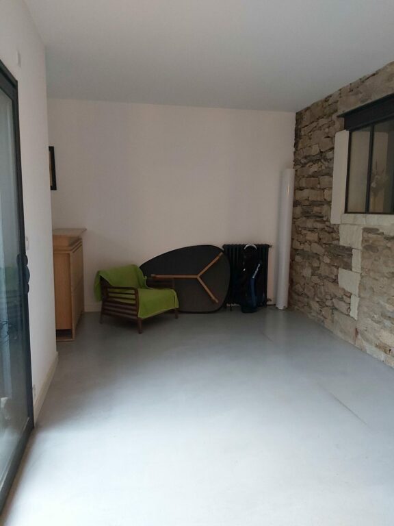 Salle à manger avant décoration avec mur en pierre apparente dans une maison rénovée à Nantes