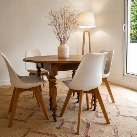 Salle à manger lumineuse rénovée après sinistre à Nantes vue depuis le salon avec mobilier mêlant ancien et contemporain.