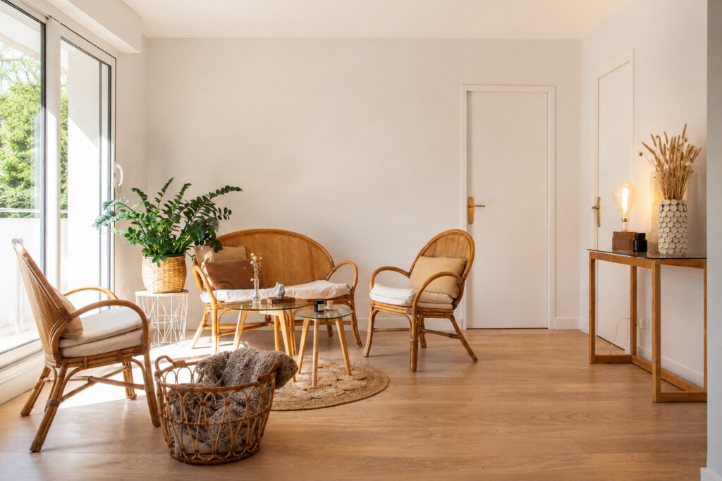 Salon rénové après un sinistre à Nantes avec mobilier en rotin, parquet bois et lumière naturelle.