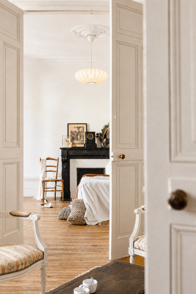 Ouverture entre les pièces de vie et la chambre mettant en valeur le patrimoine d'un appartement ancien rénové à Nantes.